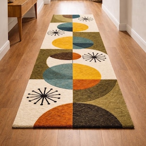 May include: A rectangular runner rug featuring a geometric pattern of circles and starburst motifs in shades of mustard yellow, teal, olive green, and burnt orange on an off-white background, with a textured pile surface and clean edges.
