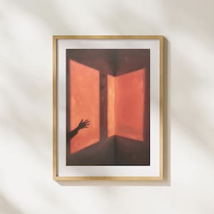 Peut inclure: Impression artistique encadrée représentant une peinture abstraite. Elle montre un coin de pièce avec deux panneaux rouge-orangé éclairés. L'ombre d'une main tendue vers la lumière. Le cadre est en bois clair.