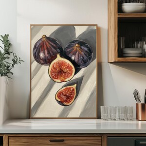 Può includere: Dipinto di natura morta incorniciato di fichi. Due fichi interi e due metà di fichi sono raffigurati in tonalità viola e rosse, con uno sfondo chiaro e ombre. L'opera d'arte è esposta in un ambiente cucina.