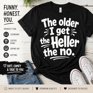 May include: Black t-shirt with white text: "The older I get the Heller the no." The shirt also has text that says "Funny. Honest. You." and "Soft, comfy & true to you."
