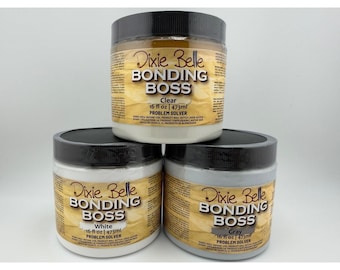 May include: Three 16 fl oz jars of Dixie Belle Bonding Boss problem solver primer. The top jar is clear, while the bottom two jars are white and gray. Each container features a black screw-top lid and a label with the product name and volume.