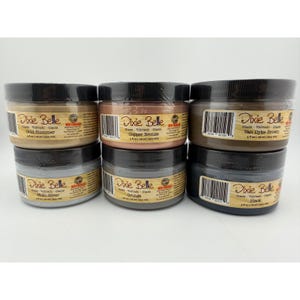 May include: A collection of Dixie Belle glaze jars in various colors, including Gold Shimmer, Copper Bronze, and Van Dyke Brown. Each jar is labeled with its color and product information. The jars are 4 fl oz / 118 ml.