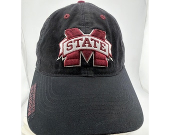 Puede incluir: Una gorra de béisbol negra con un logotipo bordado en granate y blanco en la parte frontal, que incluye la palabra STATE dentro de la letra M. El ala tiene el texto MISSISSIPPI STATE BULLDOGS bordado en granate en el borde izquierdo.
