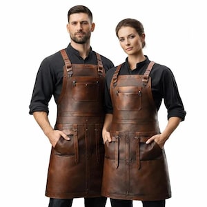 Könnte beinhalten: Zwei Personen tragen braune Leder-Schürzen mit mehreren Taschen und verstellbaren Trägern. Die Schürzen haben einen rustikalen, Vintage-Look und werden mit schwarzen Hemden kombiniert. Die Schürzen scheinen aus hochwertigem Leder zu sein.
