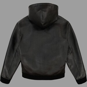 May include: Black leather hooded jacket with a black ribbed hem and cuffs. The jacket has a full-length zipper and a hood. The jacket is made of a smooth, supple leather material.