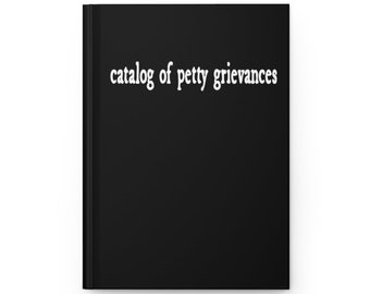 May include: A black notebook with the text "catalog of petty grievances" in white lettering.