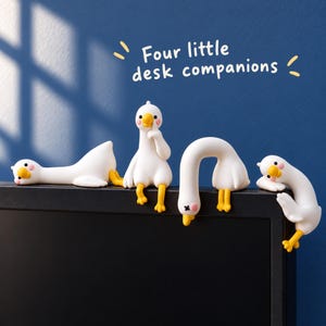 May include: Four white and yellow goose figurines in different poses, including one lying down, one sitting with a finger to its beak, one hanging upside down, and one leaning, with the text "Four little desk companions" above them.