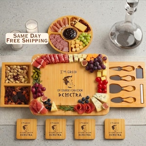May include: A bamboo charcuterie board set featuring a central serving area with the text I'M GREEK OF COURSE I CAN COOK DEMETRA, surrounded by compartments filled with meats, cheeses, nuts, and fruit, plus four matching coasters and utensils.