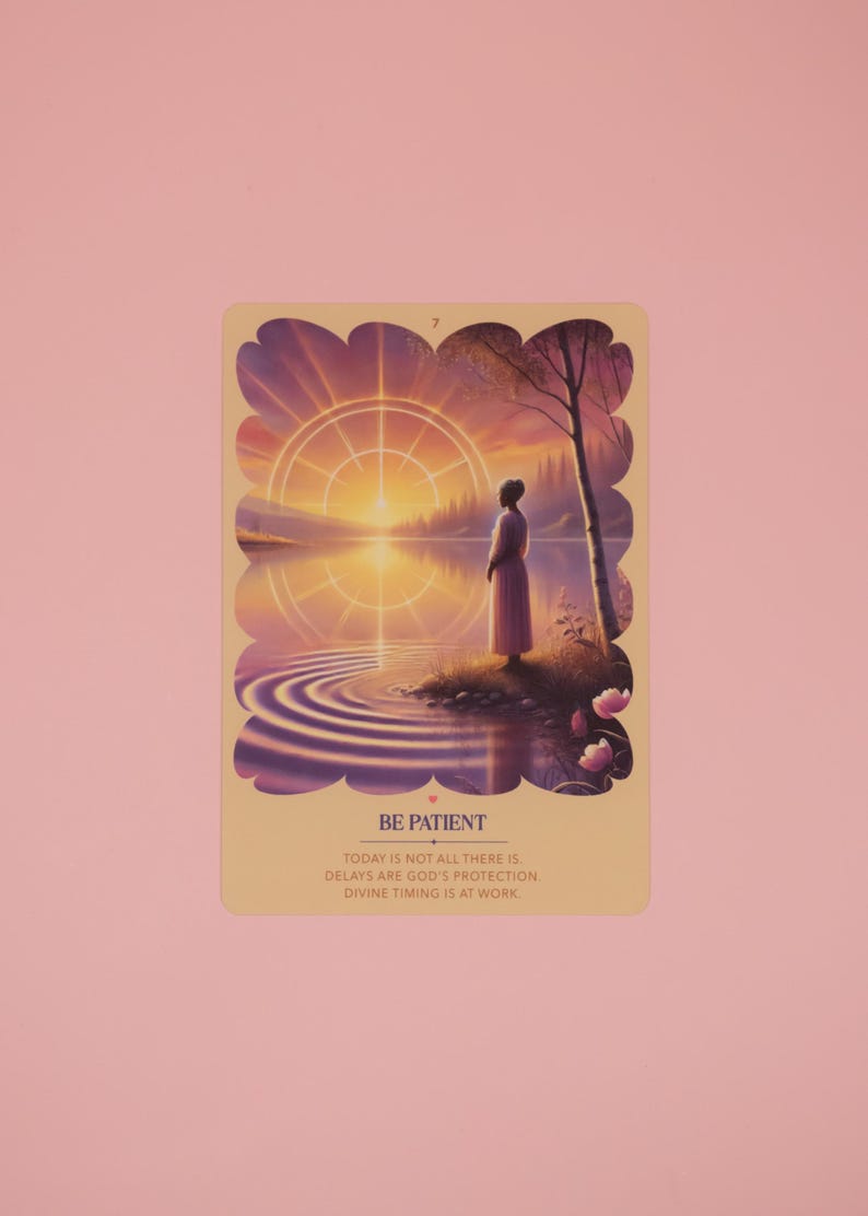 Puede incluir: Una tarjeta rectangular que muestra un atardecer sobre un lago con una persona en la orilla. El texto dice: 7, BE PATIENT, TODAY IS NOT ALL THERE IS, DELAYS ARE GOD'S PROTECTION, DIVINE TIMING IS AT WORK. La tarjeta tiene un borde festoneado.