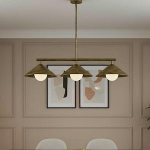 May include: A dining room set featuring a dark wood table and six upholstered chairs. Above the table is a brass chandelier with three cone-shaped shades. The walls are painted a muted pink with framed artwork.