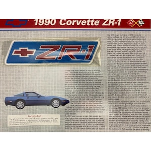 May include: A rectangular embroidered patch featuring the text ZR-1 in dark red with a white outline on a blue background, accompanied by a Chevrolet bowtie logo. The patch is displayed on a printed informational sheet about the 1990 Corvette ZR-1.