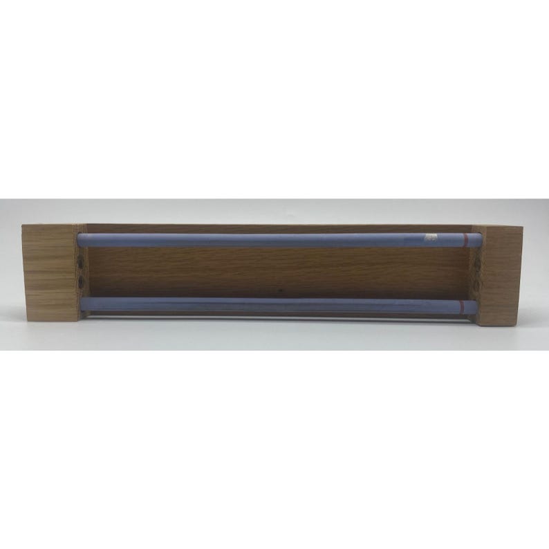 May include: A wooden shelf, rectangular in shape, featuring two parallel, pale blue rods. The shelf has a natural wood grain finish. The rods are evenly spaced within the shelf's interior, designed to hold items.