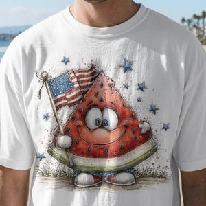 May include: White t-shirt with a cartoon watermelon slice design. The watermelon holds an American flag and is surrounded by blue stars. The design is a patriotic celebration.