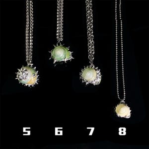 May include: Four silver necklaces with pendant designs. The pendants feature a variety of shell-like shapes in white, green, and yellow, with silver accents. The necklaces are displayed against a black background, with numbers 5, 6, 7, and 8 below.