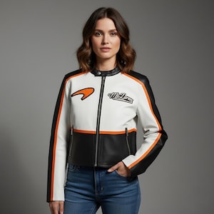 Puede incluir: Una chaqueta de estilo carreras en blanco, negro y naranja con cremallera frontal completa, cuello mao con botón a presión y el logotipo y texto de McLaren bordados en el pecho. La chaqueta tiene mangas largas con rayas naranjas.