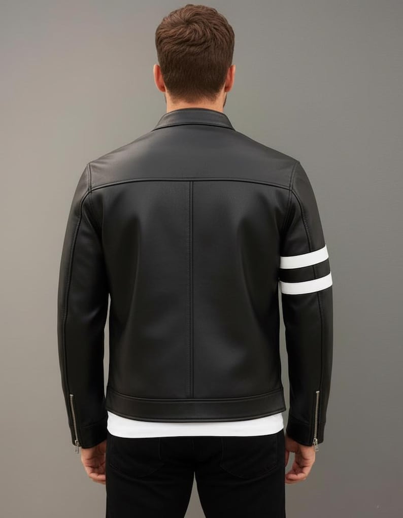 Op de afbeelding: Zwarte leren jas met witte strepen op de mouwen. De jas heeft een klassiek ontwerp met een ritssluiting en een getailleerde pasvorm. Veelzijdige bovenkleding.