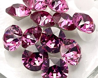 May include: A group of ten small, faceted, purple glass rhinestones. The rhinestones are arranged in a cluster on a clear glass surface.