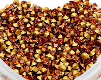 May include: A heart-shaped glass dish filled with small, gold and amber-colored rhinestones.
