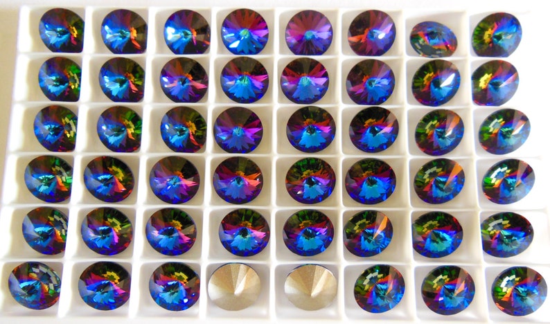 May include: A tray of 48 iridescent blue, green, and red round rhinestones in a white plastic tray.