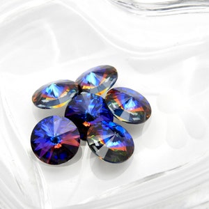 May include: Six iridescent blue round glass rhinestones with a faceted design.
