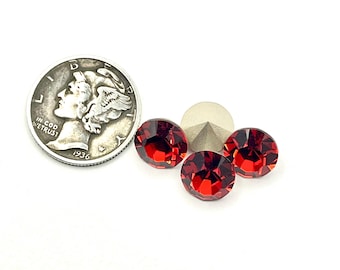 May include: Three red rhinestones, each about the size of a dime, are arranged on a white surface. A silver coin with the year 1936 is in the background for size comparison.