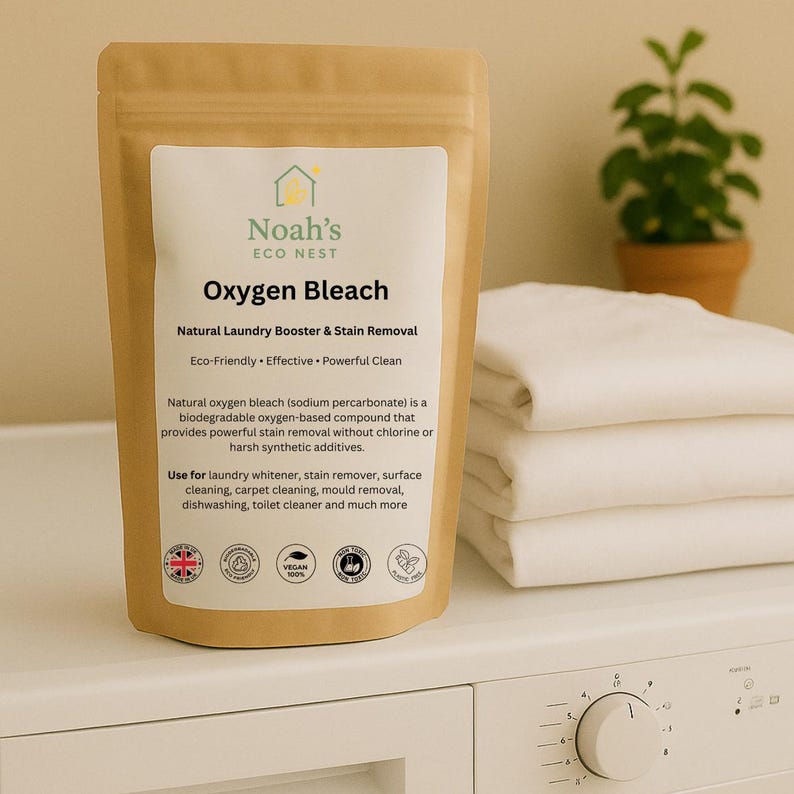 Może przedstawiać: Brązowa papierowa torba z wybielaczem tlenowym Noah's Eco Nest. Etykieta głosi "Natural Laundry Booster & Stain Removal". Produkt jest ekologiczny i skuteczny do prania i czyszczenia powierzchni. Białe ręczniki są ułożone w stos w tle.