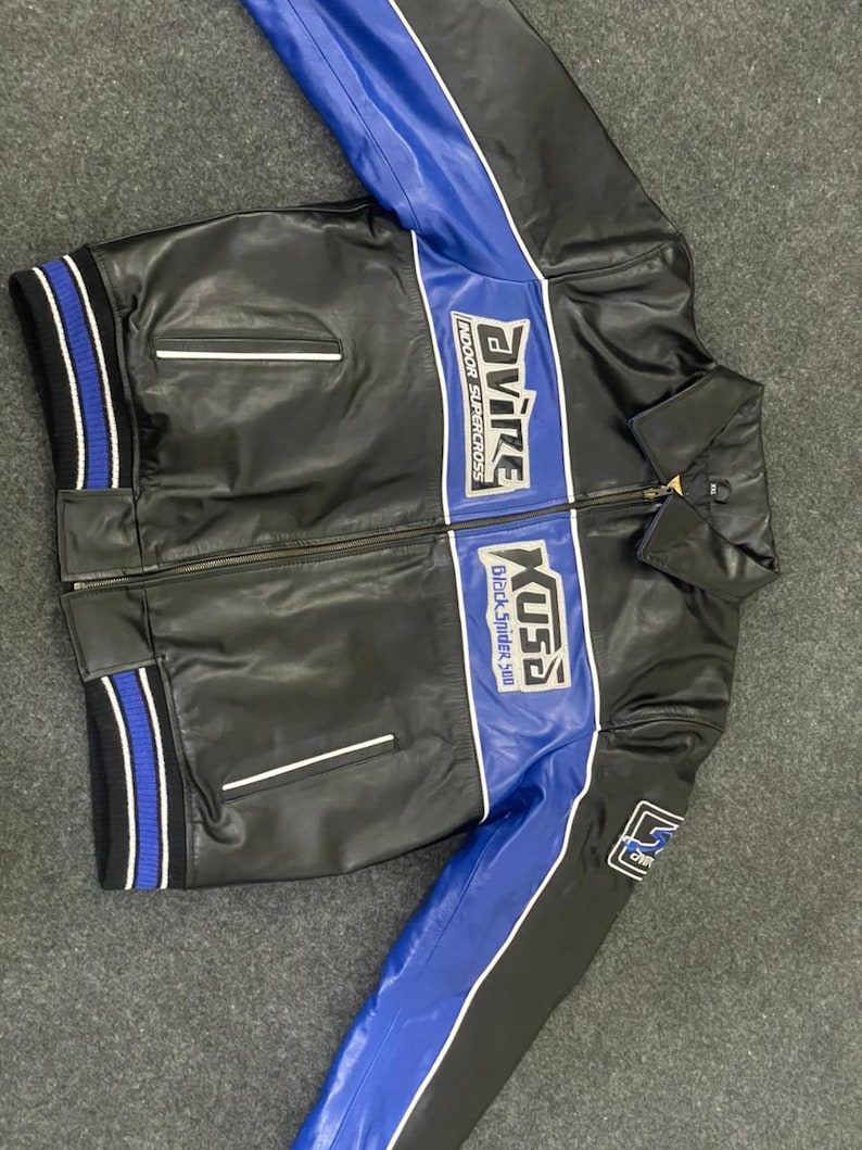 以下が含まれることがあります： 黒い革のジャケットで、青と白のアクセントが付いています。 ジャケットはジッパー開閉、2つのフロントポケット、リブ編みの袖口と裾が特徴です。 ジャケットには「Evire Indoor Supercross」と「Kusa Black Spider 310」の文字がプリントされています。