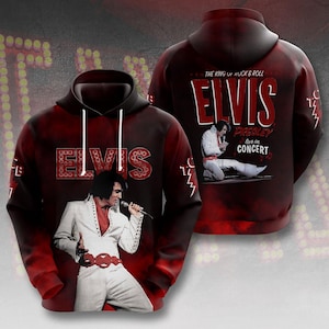 May include: A red and black Elvis Presley hoodie featuring images of Elvis in concert. The front of the hoodie displays the name "ELVIS" in a large, stylized font. The back of the hoodie has the text "The King of Rock & Roll" and "Elvis Presley live in concert".