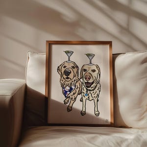 May include: A framed illustration of two golden-coloured dogs standing side by side. Each dog has a martini glass with an olive balanced on its head. The dog on the left wears a blue patterned bandana, while the dog on the right wears a collar.