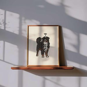 May include: A framed art print featuring a black, brown, and white Bernese Mountain Dog standing with a martini glass balanced on its head. The illustration is centered on a cream-colored background within a thin, metallic gold-toned frame.