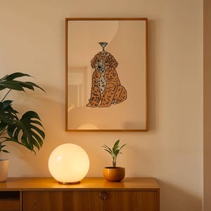 May include: A framed wall art print featuring a brown, curly-haired dog sitting down with a small martini glass balanced on its head. The illustration uses bold black outlines against a solid, light beige background within a wooden frame.