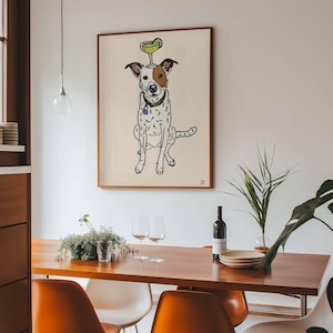 May include: A framed wall art print featuring a line-art illustration of a white dog with brown spots, wearing a collar with a blue tag, and balancing a green lime-garnished cocktail glass on its head against a light beige background.