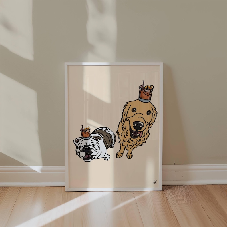 May include: A framed art print on a light beige background featuring a white and brown bulldog and a golden retriever. Each dog has a small glass of amber liquid with a garnish balanced on its head. The illustration uses bold black outlines.