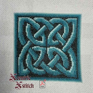 Puede incluir: Patrón de punto de cruz cuadrado con un diseño de nudo celta en tonos turquesa y negro, enmarcado por un borde turquesa sobre un fondo blanco. El texto "Xcentric Stitch" es visible en la esquina inferior izquierda.