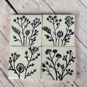 Può includere: Una tazza di ceramica bianca con manico nero e la scritta "But First, Coffee" in grassetto nero. La tazza è posta su uno sfondo sfocato, che suggerisce un'atmosfera accogliente.