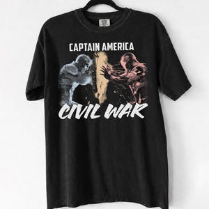 May include: Black t-shirt featuring a graphic from Captain America: Civil War. The design includes the text "CAPTAIN AMERICA" above an image of two figures and the text "CIVIL WAR" below the image.