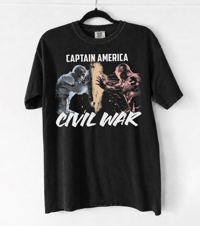 May include: Black t-shirt featuring a graphic from Captain America: Civil War. The design includes the text "CAPTAIN AMERICA" above an image of two figures and the text "CIVIL WAR" below the image.