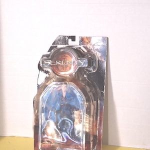 May include: A clear plastic action figure package featuring a figure in a blue outfit. The package has the word "Serenity" and Japanese characters on the top. The bottom of the package reads "Final Battle".