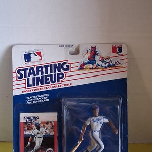 May include: A Starting Lineup collectible figure of Darryl Strawberry in a New York Mets uniform, with a baseball bat. The packaging includes a collector card and the MLB logo. The figure is in a plastic case.