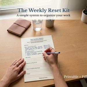 May include: A desk scene featuring a planner titled "The Weekly Reset Kit" with the text "A simple system to organize your week." A person is writing on the planner with a pen. Other items include a leather journal, a glass of water, and a small potted plant.