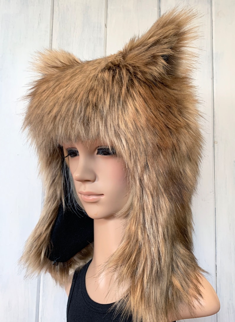 May include: A brown faux fur hat with long, floppy ears. The hat is being worn by a mannequin with long, straight hair.