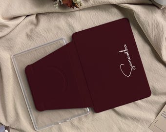 May include: A dark maroon rectangular tablet or phone stand featuring a smooth, matte finish. The surface displays the name Samantha in a white, elegant cursive script. The stand is positioned partially over a clear, transparent plastic frame.