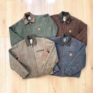 Puede incluir: Un juego de tres tazas de cerámica con un acabado mate moteado. Las tazas son de color crema, gris claro y gris oscuro. Cada taza tiene un diseño simple y minimalista.