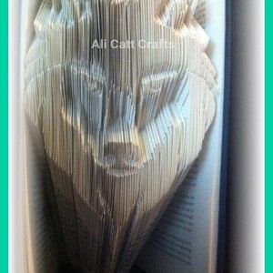 May include: A book with pages folded into the shape of a wolf's head. The book is open and the wolf's head is facing the viewer. The text "Ali Catt Crafts" is visible on the book.
