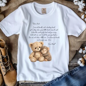 May include: White t-shirt featuring a watercolor illustration of a teddy bear and a monkey hugging. The shirt includes a poem about comfort and love. The text reads "Dear Puck" and "Your Plush".