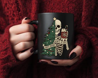 May include: Black ceramic mug featuring a skeleton with a Christmas tree design. The skeleton holds a mug with a snowflake design and the text "Sorta Scary" and "Sorta Merry". The mug has a black handle.