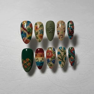 Peut inclure: Dix faux ongles décorés de motifs variés. Les ongles présentent des motifs floraux, des notes de musique, une coccinelle et des tourbillons abstraits dans des couleurs comme le vert, le rouge, le bleu et le jaune. Certains ongles sont mats, d'autres brillants.