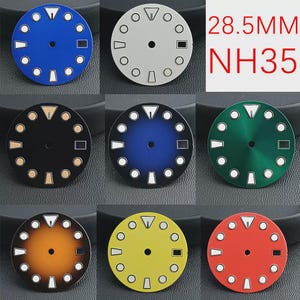 May include: A selection of watch dials in diverse colours, such as blue, black, green, yellow, and red. Each dial has white and silver hour markers and hands, with the text "28.5MM NH35" in red. The dials are approximately 2.85 cm in diameter.