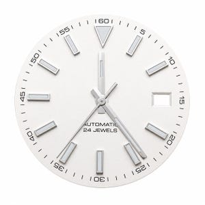 Puede incluir: Una esfera de reloj redonda de color blanco con marcadores de hora plateados con inserciones luminosas, un marcador triangular en la posición de las doce y manecillas plateadas. El texto AUTOMATIC 24 JEWELS está impreso en negro.