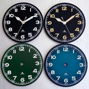 Puede incluir: Cuatro esferas de reloj circulares dispuestas en cuadrícula. Las dos superiores tienen manecillas, números blancos o dorados y una flecha. Las dos inferiores, en verde y azul, muestran números blancos y una flecha, sin manecillas.